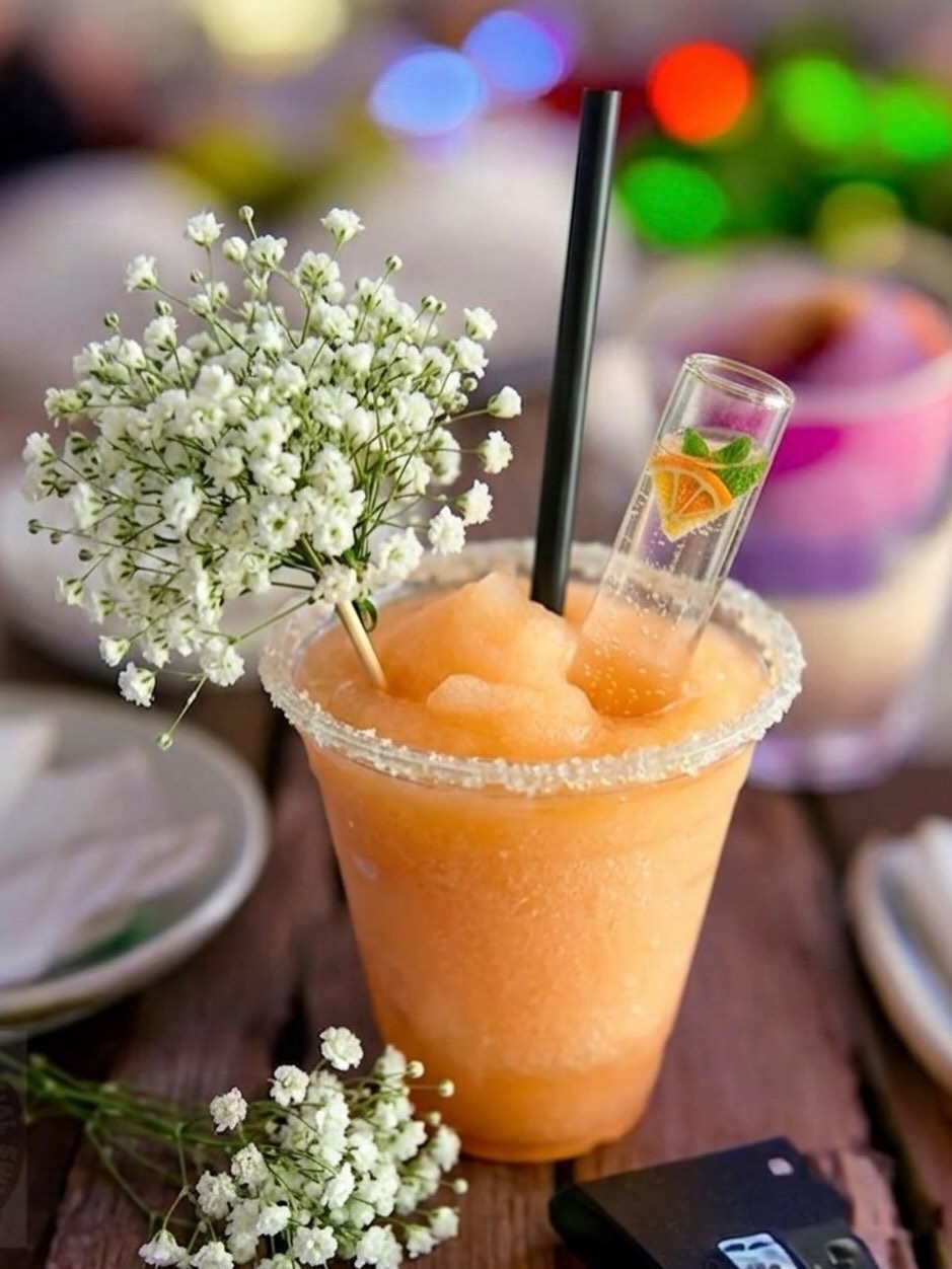 A peach slushie cocktail with baby's breath garnish at a recent wedding